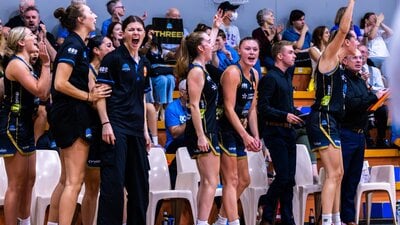 The bench players of a basketball team cheering.