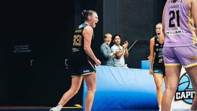 Two basketball players cheer for each other after making a tough shot.