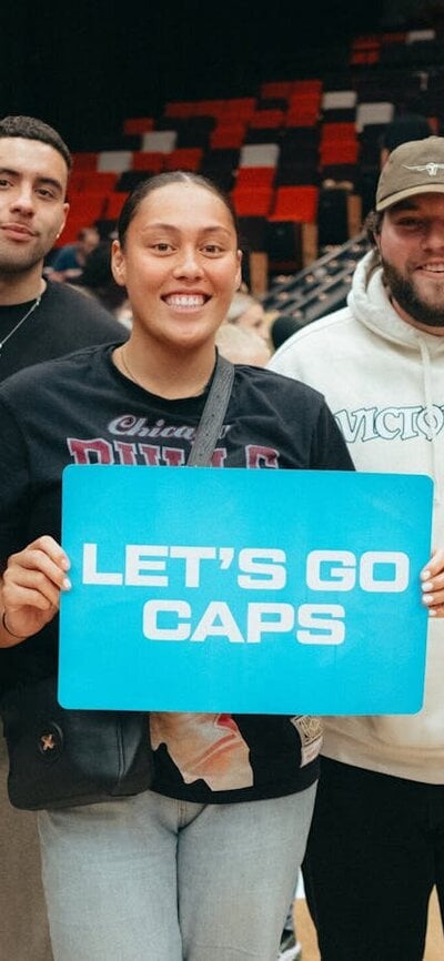 UC Captials fans showing support for the team by holding up a sign that states "let's go Caps" .....