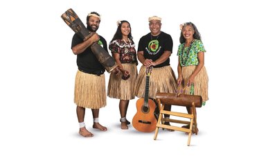 4 musicians stand, wearing grass skirts, holding a guitar and wooden percussion instruments