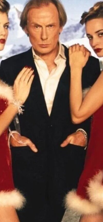 Love Actually (2003) Man standing in centre surrounded by women wearing sexy santa costumes