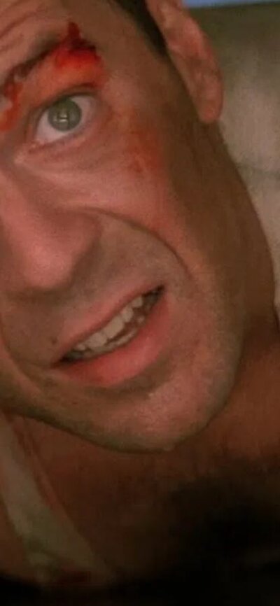 Die Hard (1988) Man with blood on his face looking up squeezed in a tight space