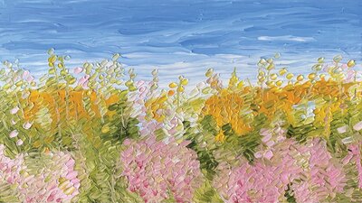 A meadow of pink, white and yellow flowers with a blue sky.