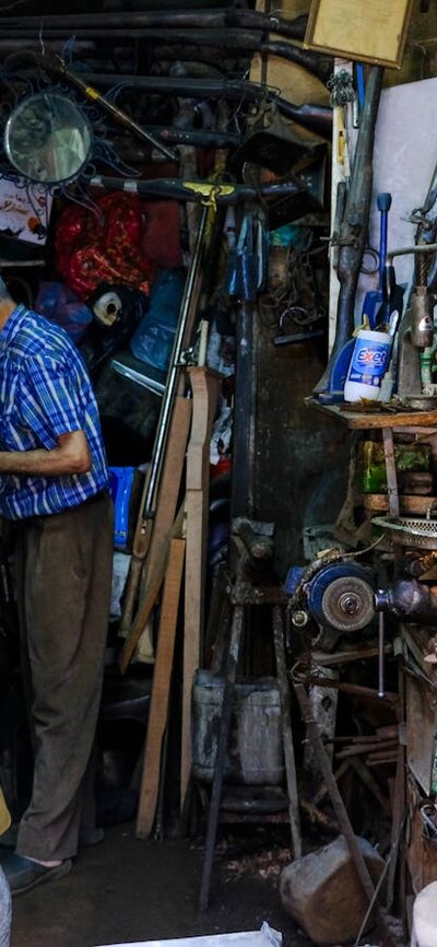 A man works in a cluttered workshop