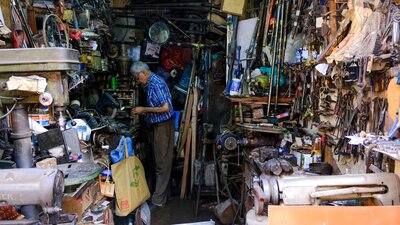 A man works in a cluttered workshop